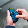 Removing the rechargeable battery pack from a Bosch 50m green beam laser measure.