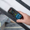 Using the 360-degree tilt sensor on a Bosch 50m laser measure to check stair railing incline.
