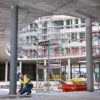 Measuring vertical distance with a high-visibility green beam laser on a large scale construction project.